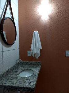 a bathroom with a sink and a mirror at Pousada Império in São Miguel do Gostoso