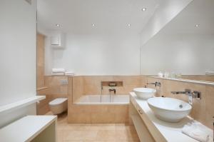 a bathroom with two sinks and a bath tub at 35qm Deluxe Apartment Suites im Stil Design Hotel Vosteen Nähe der Kaiserburg in Nuremberg +4 photos