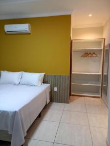 - une chambre avec un lit blanc et un placard dans l'établissement Pousada Império, à São Miguel do Gostoso