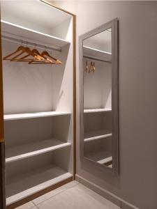 a walk in closet with a mirror and hangers at Pousada Império in São Miguel do Gostoso