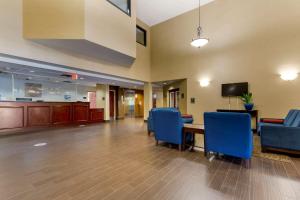 an empty lobby with blue chairs and a table at Comfort Inn & Suites Cambridge in Cambridge