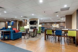 un hall avec des chaises et des tables colorées ainsi qu'une cafétéria dans l'établissement Comfort Inn Binghamton I-81, à Binghamton