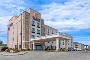 a hotel building with an american flag in front of it at Comfort Inn & Suites Mandan - Bismarck in Mandan