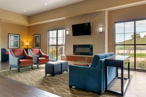 a living room with chairs and a tv and a couch at Comfort Inn & Suites Mandan - Bismarck in Mandan