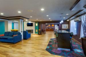Comfort Inn West Valley - Salt Lake City South في ويست فالي سيتي: غرفة معيشة مع أريكة زرقاء وبار
