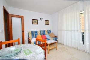 ein kleines Wohnzimmer mit einem Tisch und einem Stuhl in der Unterkunft Parque Europa - Fincas Arena in Benidorm