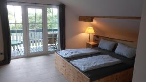 a bedroom with a bed and a balcony at Ferienhaus Damberg in Übersee