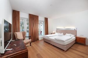 a bedroom with a bed and a flat screen tv at 120qm Deluxe Apartment Suites Christina im Stil Design Hotel Vosteen Nähe der Kaiserburg in Nürnberg