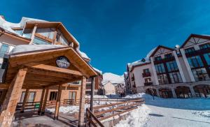 a building with a sign on it in the snow at Gudauri Cozy Home in Gudauri