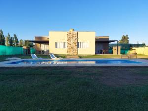 una casa con piscina frente a ella en Cabañas Mágico Atardecer en San Rafael