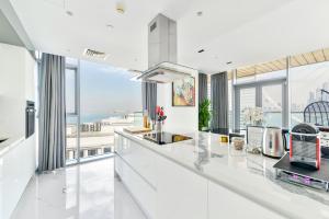 a kitchen with white countertops and large windows at Luxurious 3 BR w maidroom in BLUEWATERS ISLAND in Dubai