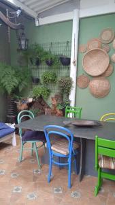 a table and chairs with plants on a wall at Suítes Família Mateus in Ubatuba