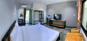 - une chambre avec un lit blanc et une télévision dans l'établissement D-2 Home, à Chanthaburi