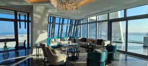 - un salon avec un canapé, des chaises et un lustre dans l'établissement Waterfront Hotel Apartment, à Lusail