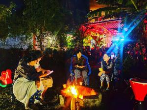 a group of people sitting around a fire at night at Dream Vision Guest House in Diu