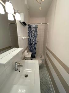 une salle de bain avec un lavabo blanc et des toilettes dans l'établissement L'Appartement de la Plage, à Saint-Quay-Portrieux 41 autres photos