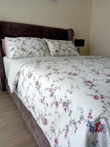 a bed with a white blanket with flowers on it at Al Zahra Homestay by Troika Kota Bharu in Kota Bharu