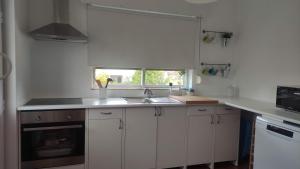 een witte keuken met een wastafel en een raam bij Casa da Bia - AL em Arcos de Valdevez in Arcos de Valdevez +12 foto's