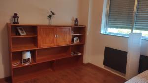 een boekenplank in een slaapkamer met een raam bij Casa da Bia - AL em Arcos de Valdevez in Arcos de Valdevez