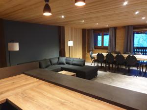 a living room with a couch and a table and chairs at CHALET LES CERFS in Châtel