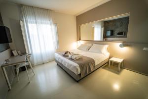 - une chambre avec un lit avec un miroir et une table dans l'établissement Hotel Cave Del Sole, à Matera