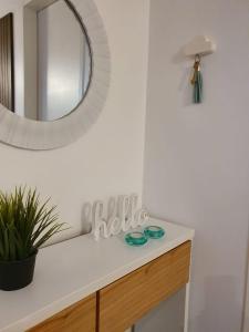 NidoAparte Departamento Lujan Centro في لوجان: منضدة حمام مع مرآة ومغسلة