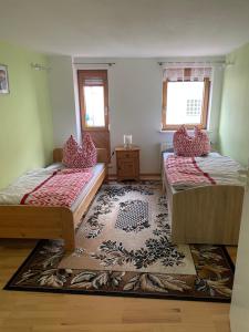 Cette chambre comprend 2 lits et un tapis. dans l'établissement Super große Ferienwohnung für bis zu 5 Personen, à Owen