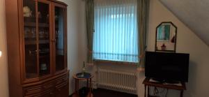 een woonkamer met een tv en een raam bij Appartement Viersen in Fehmarn