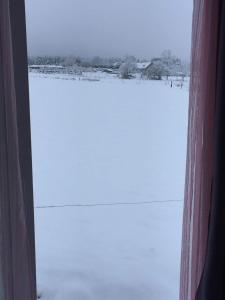een raam met uitzicht op een besneeuwd veld bij Le DiamanSter Francorchamps in Stavelot