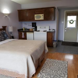 a small bedroom with a bed and a kitchen at Antigonish Evergreen Inn in Antigonish