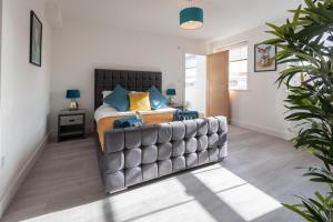 una camera da letto con un grande letto con cuscini blu di Smart Apartments - Atlantic Mansions a Southampton