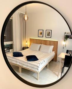 una camera da letto con un letto con due cuscini in uno specchio di Kaari Home - Studio Apartment In the Heart of Tampere Next to Nokia Arena a Tampere