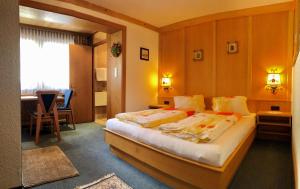 a hotel room with a bed and a dining room at Alpenruh in Pettneu am Arlberg