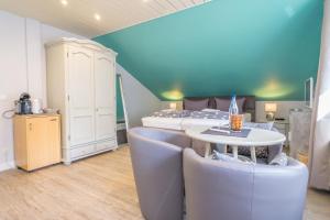 a bedroom with a bed and a table and chairs at Froschkönig in Westerland