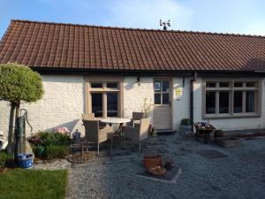 une maison avec une table et des chaises devant elle dans l'établissement DHofstede vakantiewoning, à Audenarde