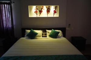 MarudhamalaiSremethila Homestay的一间卧室配有一张床,并展示芭蕾舞者的照片