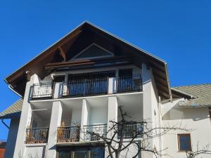 un edificio blanco con balcones y techo en BALCON Apartments en Bled