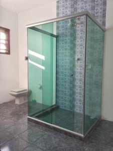 a glass shower in a bathroom with a toilet at Varandas do Arraial- Hostel in Arraial do Cabo