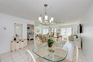 a dining room with a glass table and chairs at Anna Maria Island Beach Sands 203 in Bradenton Beach