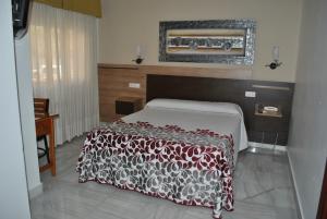 
a bedroom with a bed and a dresser at Hotel Albero in Granada
