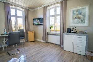 an office with a desk and chairs and windows at Rotkäppchen in Westerland
