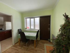 a room with a table and chairs and a christmas tree at ZWIN Apartment 2 in Skole
