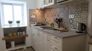 eine Küche mit Theke und Spüle und einem Fenster in der Unterkunft Casa TRIGO in Cómpeta