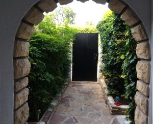 an archway leading to a black door with ivy at Studio Framboise proche Paris et Disneyland in Gagny