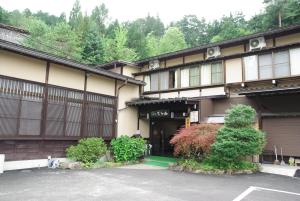 a building with a parking lot in front of it at Ryokan Murayama in Takayama