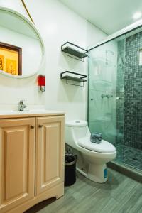 a bathroom with a toilet and a glass shower at Hotel Revolución in Tijuana