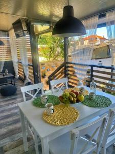 een witte tafel met een fruitschaal erop bij La Veranda Sinemorets in Sinemorets