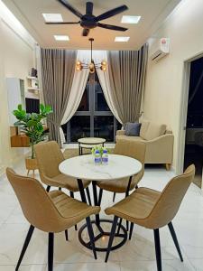 uma sala de estar com mesa e cadeiras em Al Zahra Homestay by Troika Kota Bharu em Kota Bharu