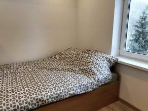 a bed sitting in a room next to a window at Zielony Zakątek in Złota