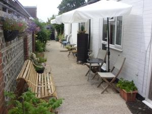 un patio con bancos y una sombrilla en una casa en Ashdene Guest House, en Southampton